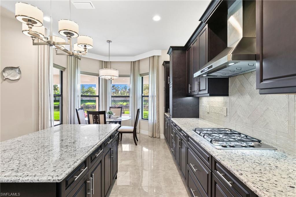 4370 Caldera Circle Naples, FL 34119 - Photo 8 of 35 a kitchen with stainless steel appliances granite countertop a sink a stove and a wooden floors