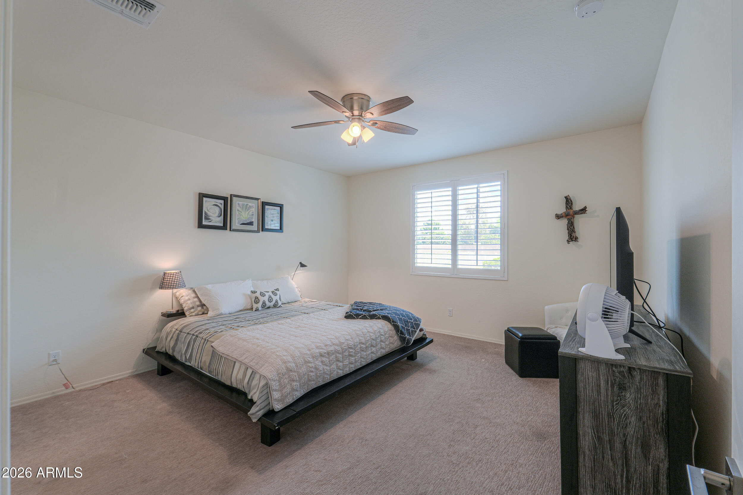 42085 West Cribbage Road Maricopa, AZ 85138 - Photo 21 of 35 a bedroom with a bed and a chandelier