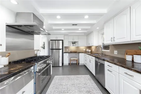 a kitchen with granite countertop white cabinets and window