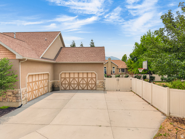 1279 West 1500th Street North Mapleton, UT 84664 - Photo 74 of 83 Stucco exterior featuring a two-car garage with decorative wooden doors and stone detailing
