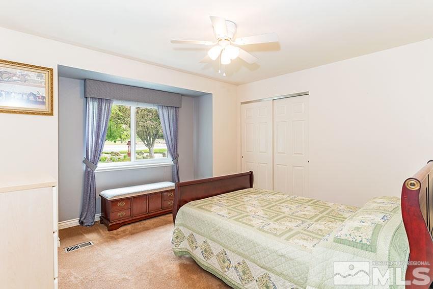 14345 Chamy Drive Reno, NV 89521 - Photo 12 of 15 a spacious bedroom with a bed and a chandelier