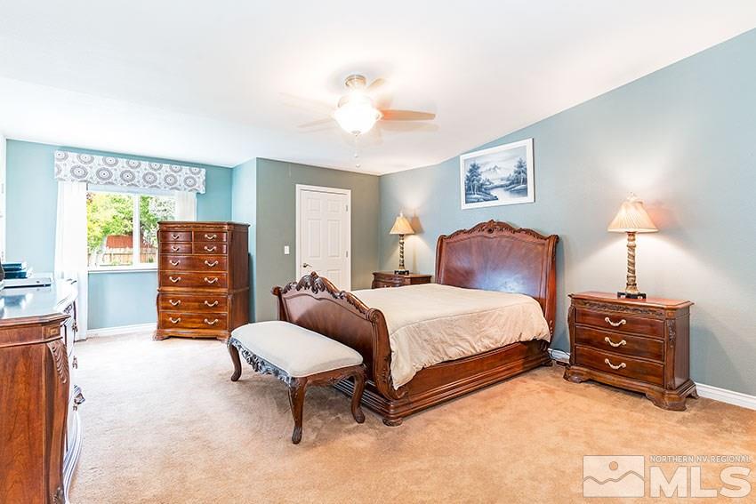 14345 Chamy Drive Reno, NV 89521 - Photo 9 of 15 a spacious bedroom with a bed and dresser with mirror