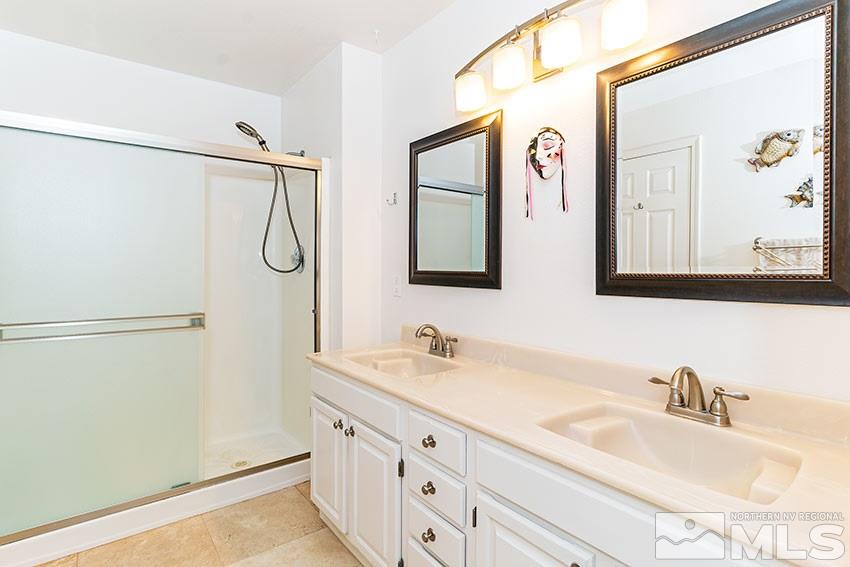14345 Chamy Drive Reno, NV 89521 - Photo 10 of 15 a bathroom with a double vanity sink a mirror and a shower