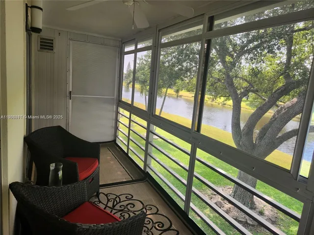 a living room with furniture and a floor to ceiling window