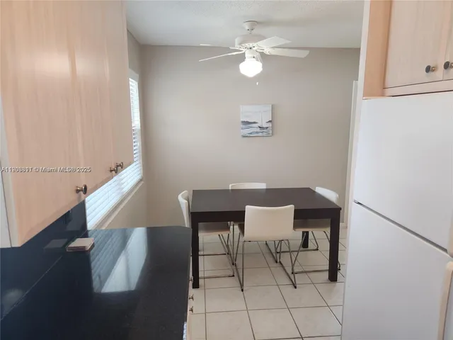 a view of a dining room with furniture and a chandelier fan