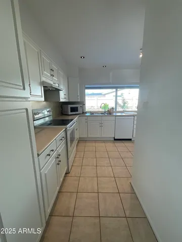 a kitchen with a sink a stove top oven and cabinets