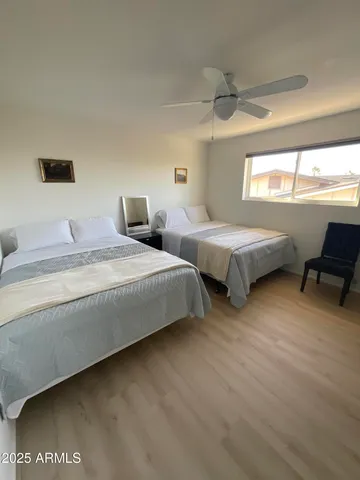 a bedroom with two beds and a desk