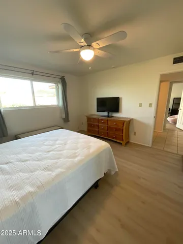 a spacious bedroom with a bed and a flat screen tv