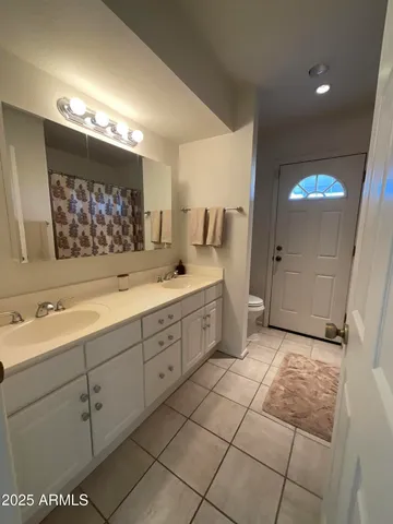 a spacious bathroom with a double vanity sink mirror and bathtub