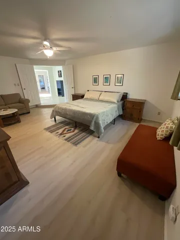 a spacious bedroom with a bed a couch and dresser