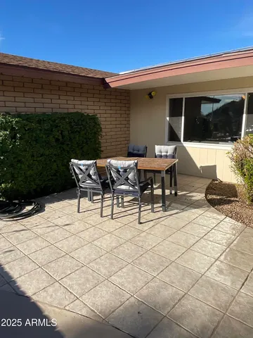a view of a patio with table and chairs with wooden floor and fence