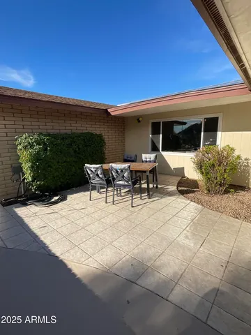 a view of a patio with dining table and chairs with wooden floor