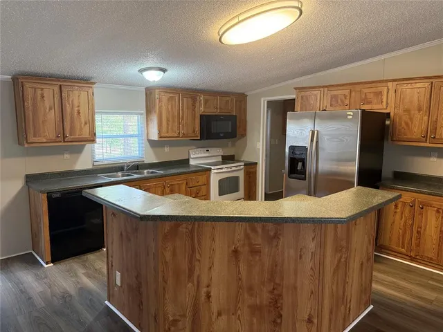 a kitchen with stainless steel appliances granite countertop a refrigerator a sink and a stove