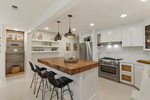 a kitchen with stainless steel appliances granite countertop a stove a refrigerator and a refrigerator