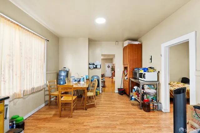 a kitchen with a refrigerator a stove a sink dishwasher and a dining table with wooden floor