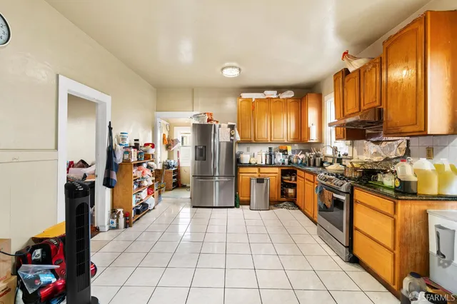a kitchen with stainless steel appliances a stove refrigerator and cabinets