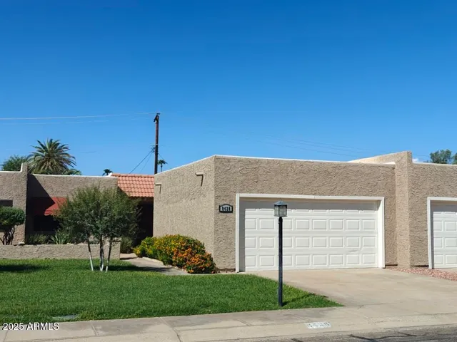 a view of a white house with a yard