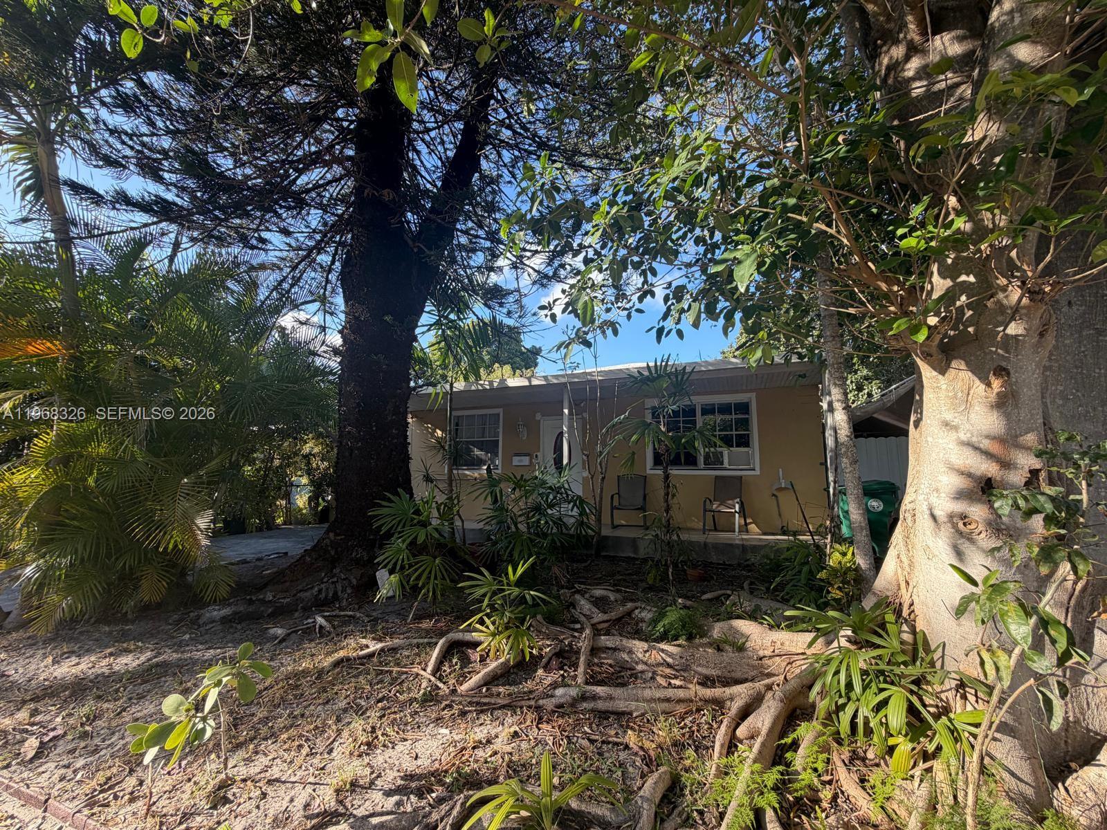 4729 Southwest 4th Street Miami, FL 33134 - Photo 2 of 4 a view of backyard with wooden fence and a large tree