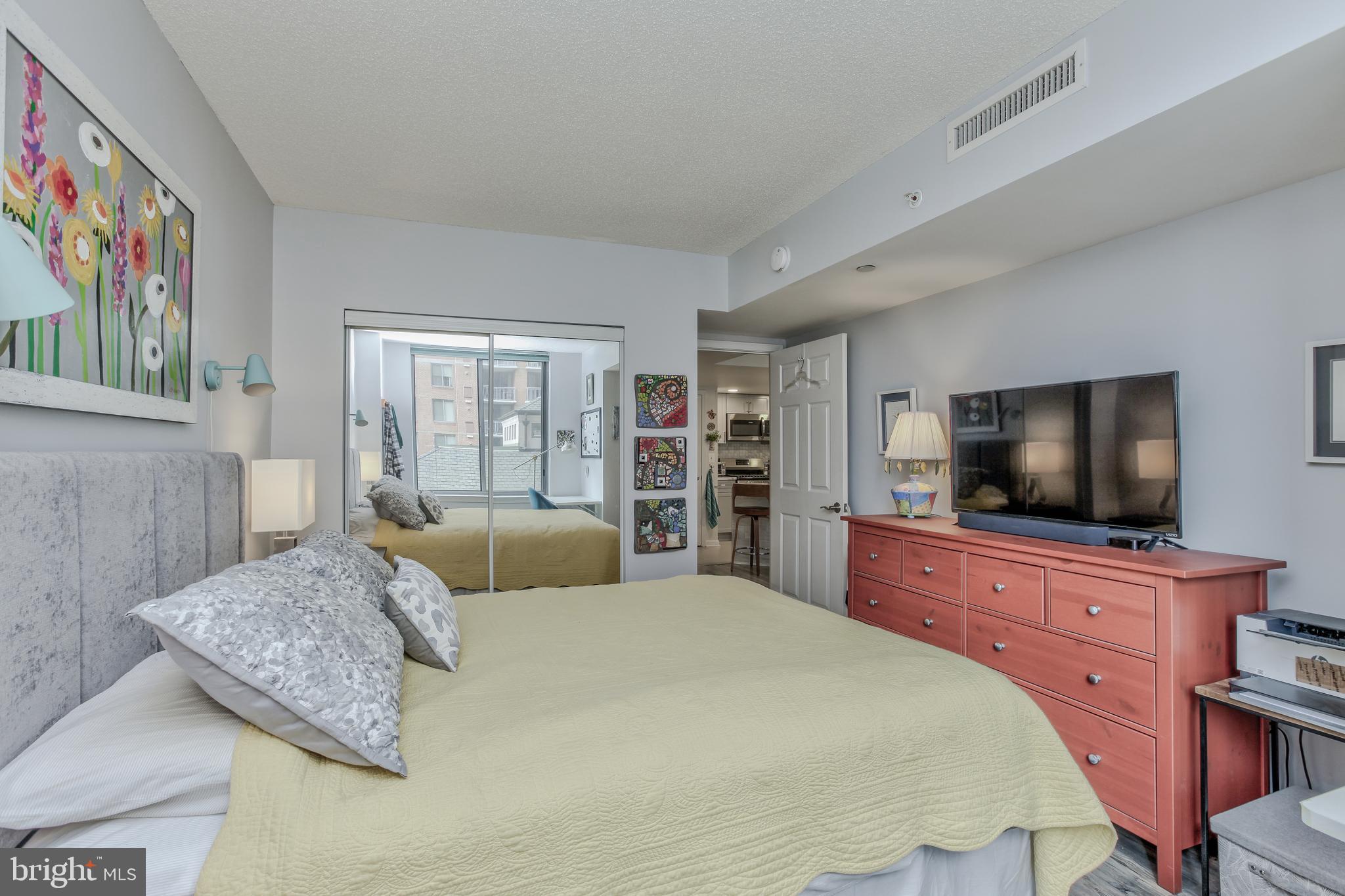 11710 Old Georgetown Road, Unit 422 North Bethesda, MD 20852 - Photo 16 of 28 a bedroom with a large bed and a flat screen tv