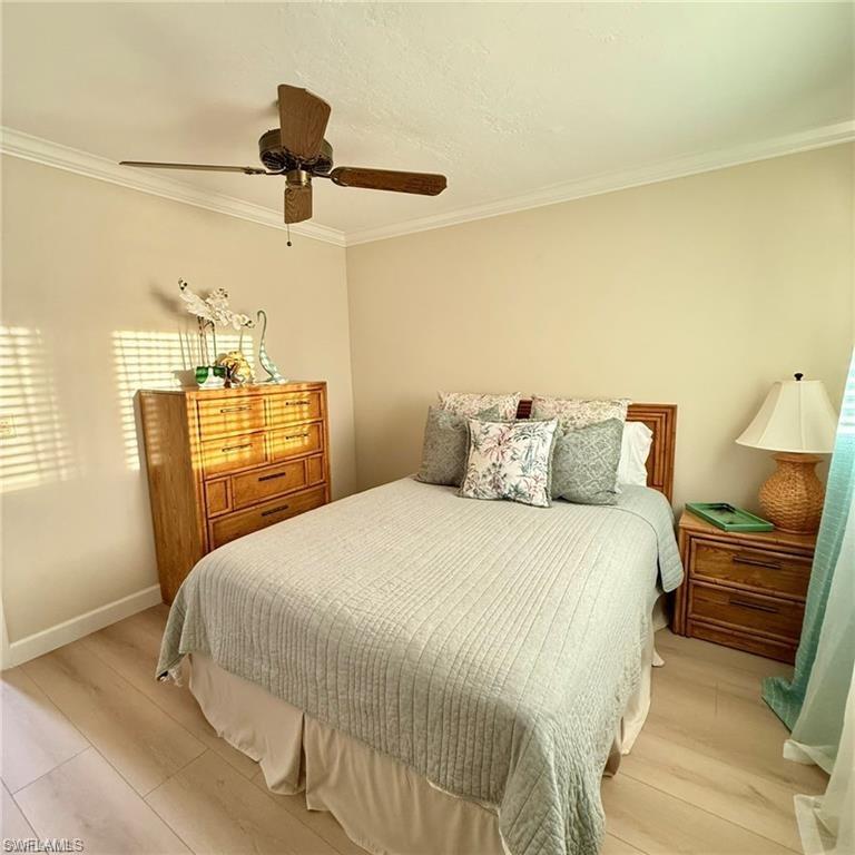 57 High Point Circle West, Unit 201 Naples, FL 34103 - Photo 12 of 18 a bedroom with a bed and wooden floor