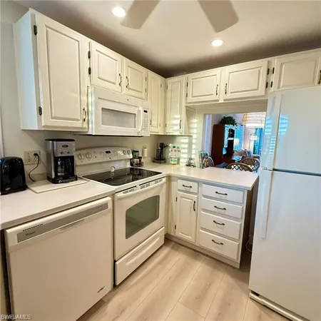 a kitchen with granite countertop cabinets and white appliances