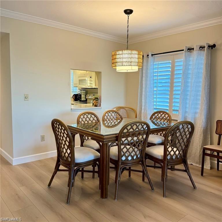 57 High Point Circle West, Unit 201 Naples, FL 34103 - Photo 2 of 18 a view of a dining room with furniture wooden floor and chandelier