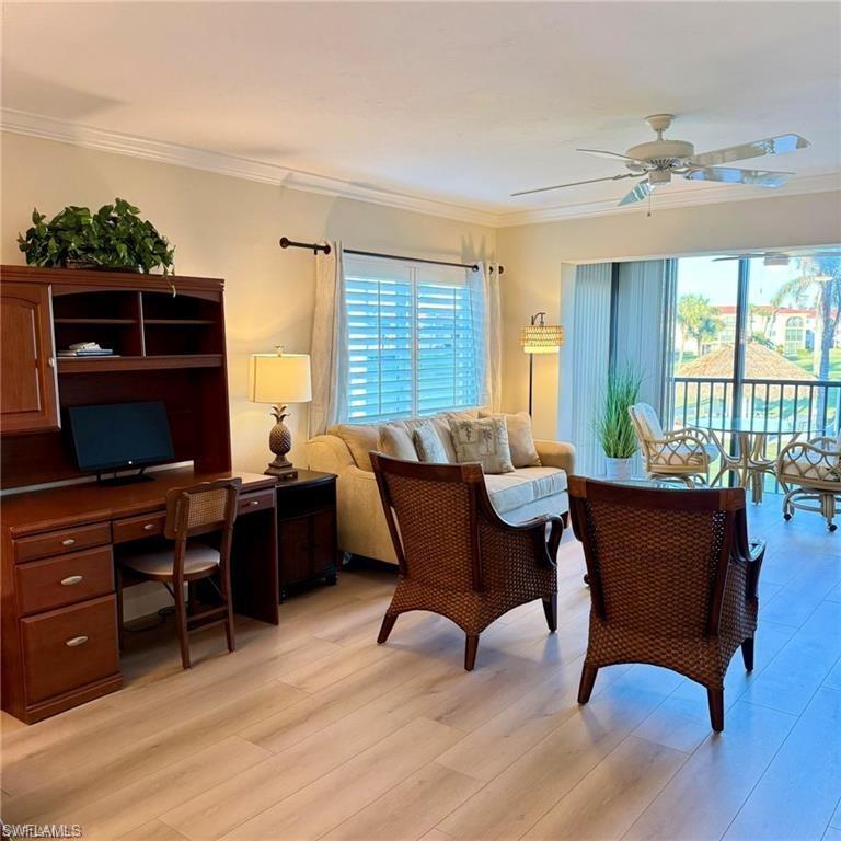 57 High Point Circle West, Unit 201 Naples, FL 34103 - Photo 3 of 18 a living room with furniture a flat screen tv and a window