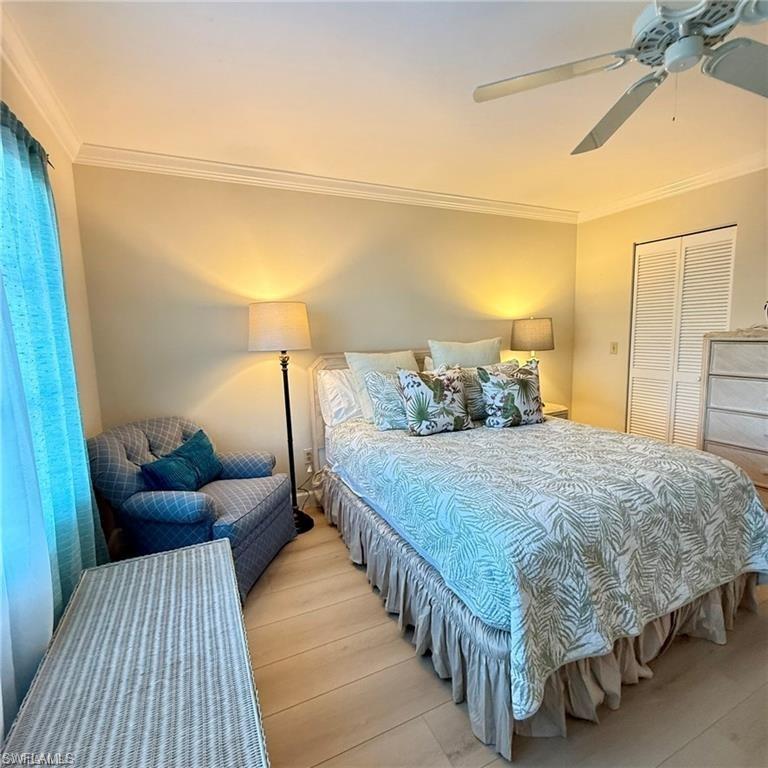 57 High Point Circle West, Unit 201 Naples, FL 34103 - Photo 7 of 18 a bedroom with a bed and a night stand