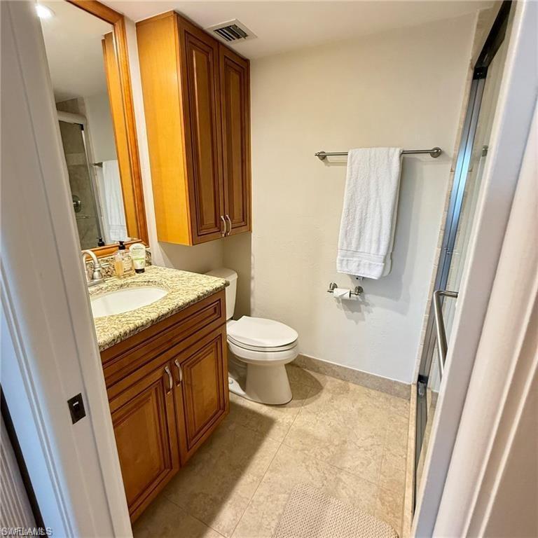 57 High Point Circle West, Unit 201 Naples, FL 34103 - Photo 8 of 18 a bathroom with a sink a toilet and a mirror