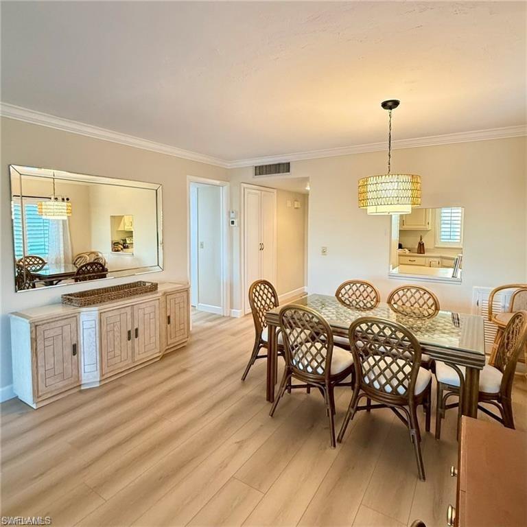 57 High Point Circle West, Unit 201 Naples, FL 34103 - Photo 10 of 18 a living room with furniture a dining table and a stove top oven