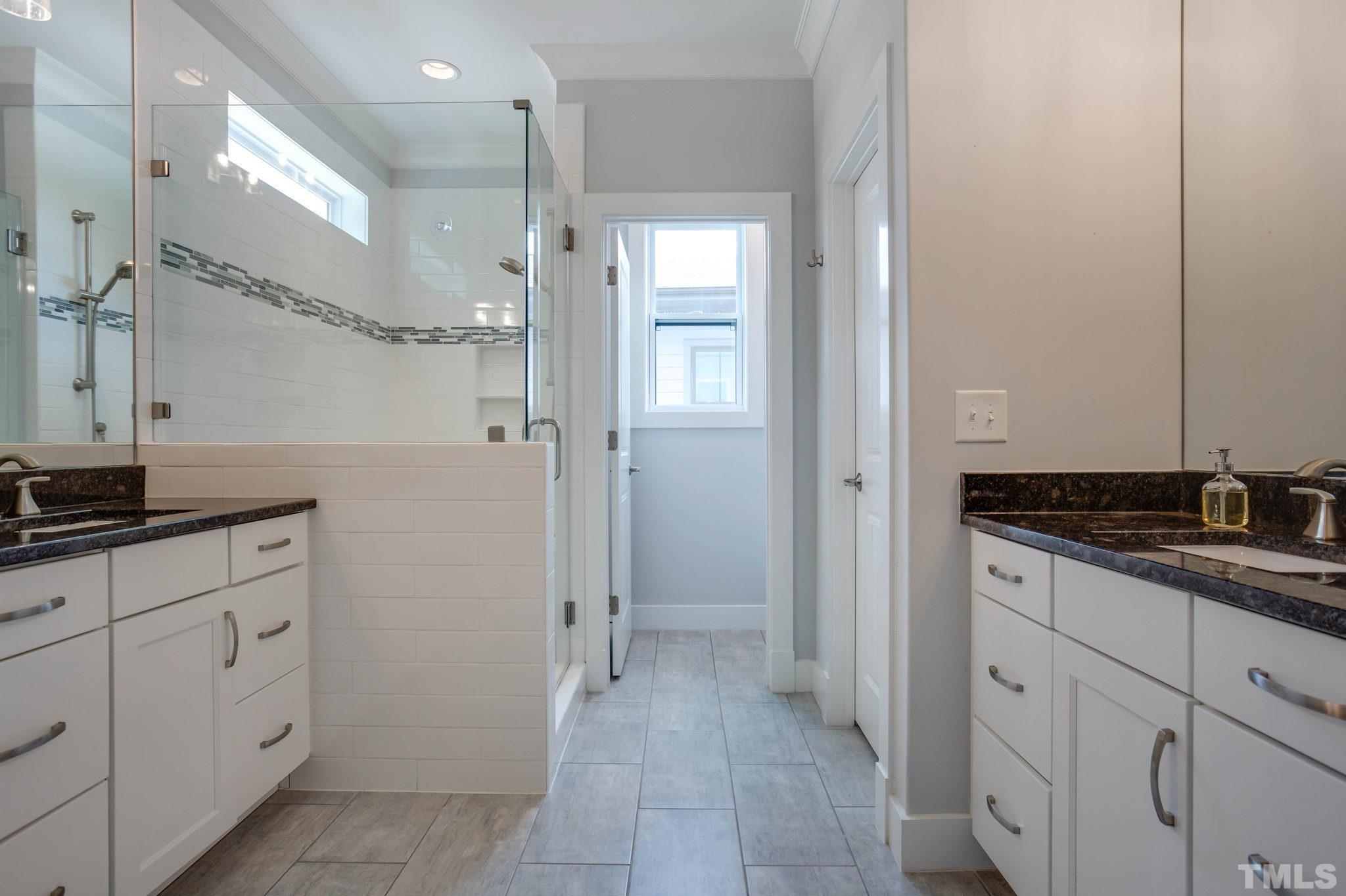 1702 Bickett Boulevard Raleigh, NC 27608 - Photo 22 of 41 a bathroom with a granite countertop sink two mirror and a shower