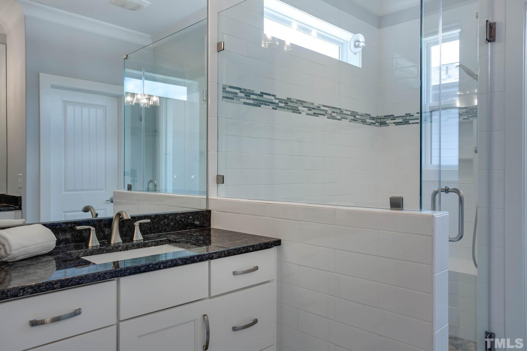 1702 Bickett Boulevard Raleigh, NC 27608 - Photo 23 of 41 a bathroom with a granite countertop sink a mirror and shower