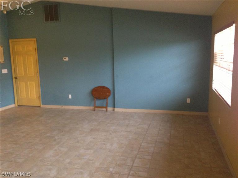 348 Rancho Avenue Lehigh Acres, FL 33974 - Photo 2 of 10 a view of an empty room with a window