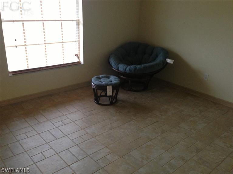 348 Rancho Avenue Lehigh Acres, FL 33974 - Photo 7 of 10 a living room with a couch and a window