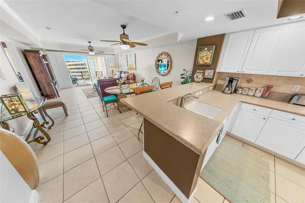 a large white kitchen with a stove a sink dishwasher and cabinets