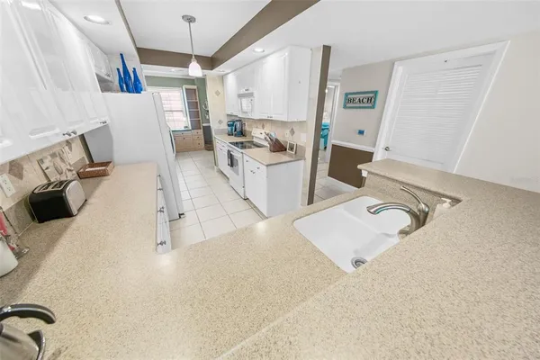 a kitchen that has a lot of cabinets and appliances