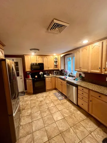 a large kitchen with a large counter top stainless steel appliances and cabinets