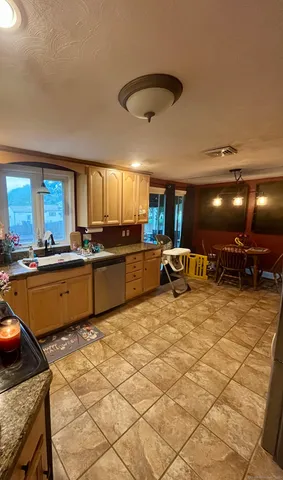 a large kitchen with stainless steel appliances kitchen island granite countertop a sink and cabinets