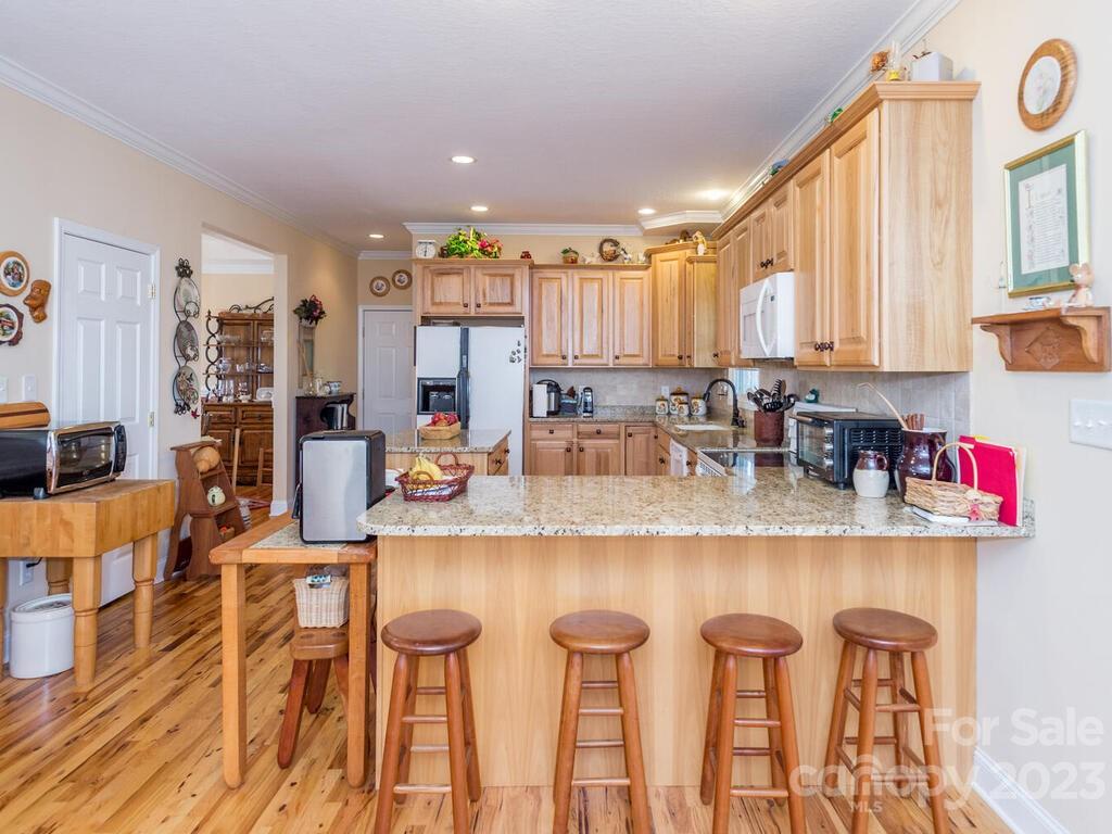 264 Hazel Brook Road Marshall, NC 28753 - Photo 21 of 47 a kitchen with stainless steel appliances granite countertop a table chairs and a refrigerator