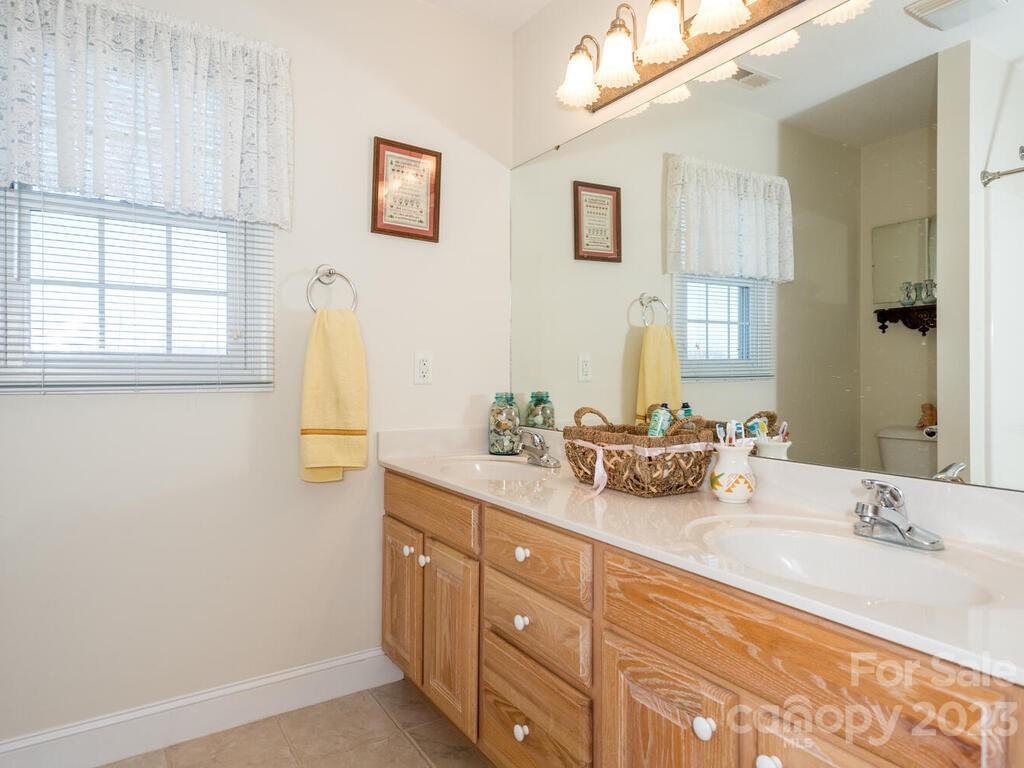 264 Hazel Brook Road Marshall, NC 28753 - Photo 32 of 47 a bathroom with a double vanity sink a mirror and a bathtub