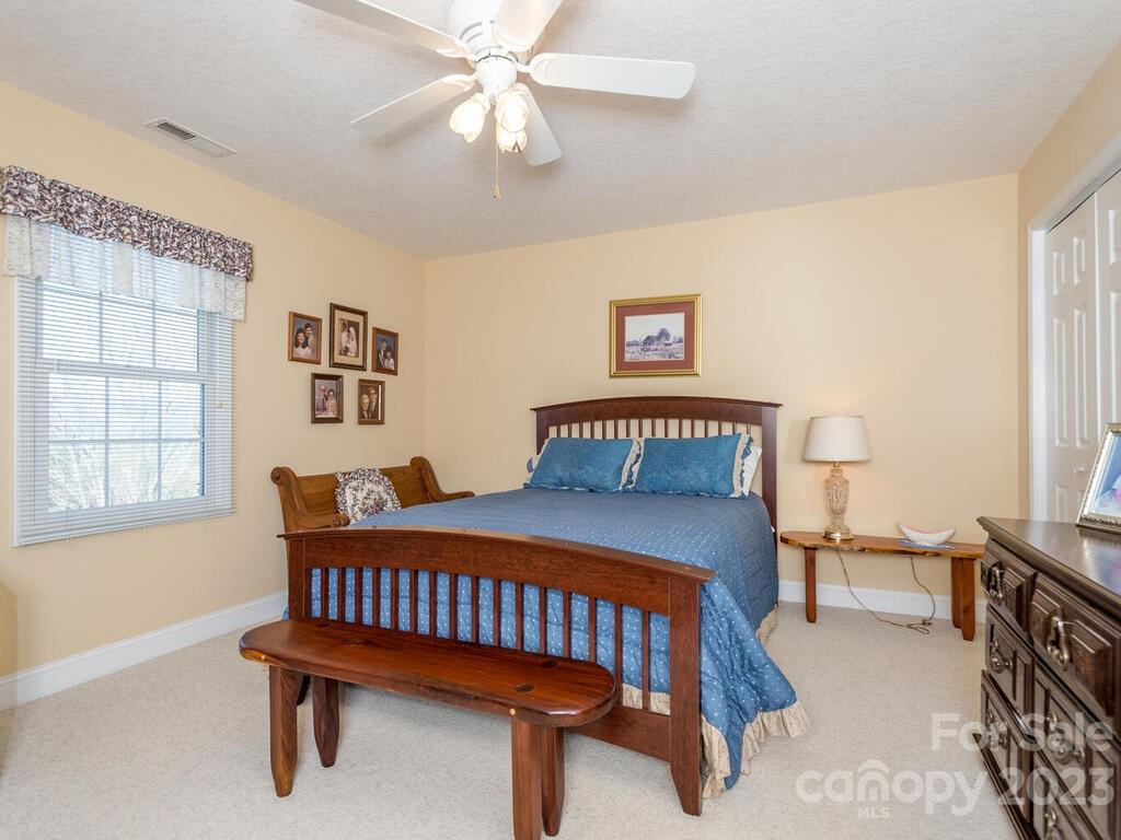 264 Hazel Brook Road Marshall, NC 28753 - Photo 33 of 47 a bedroom with a bed and a chandelier