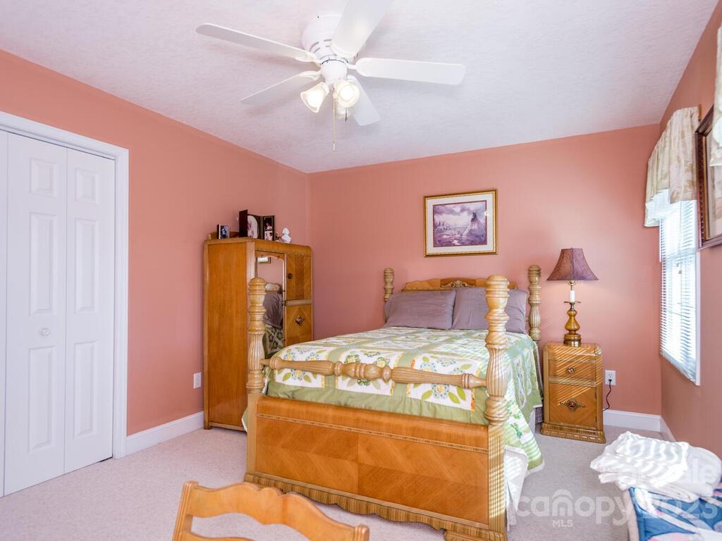 264 Hazel Brook Road Marshall, NC 28753 - Photo 35 of 47 a bedroom with a bed and a chandelier