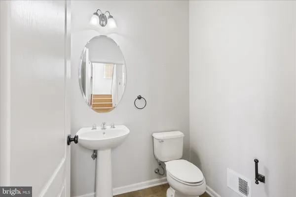 a bathroom with a sink toilet and a mirror
