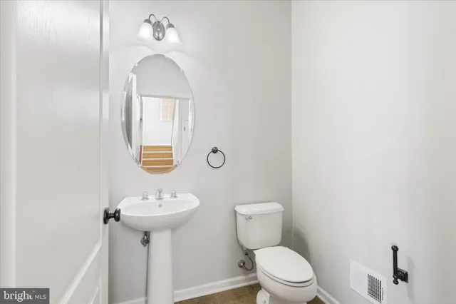 a bathroom with a sink toilet and a mirror