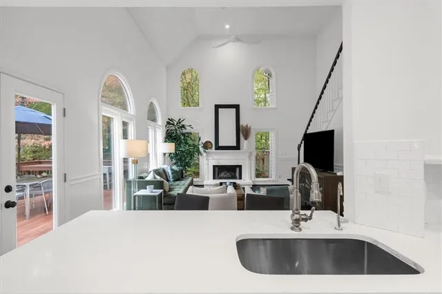 a living room with fireplace furniture wooden floor and a large window