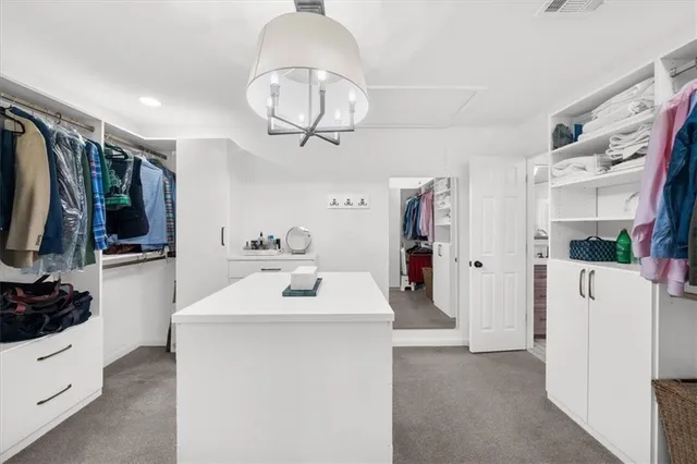 a view of a brick house next to a yard with large trees
