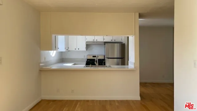 a kitchen with stainless steel appliances a microwave a sink and a refrigerator
