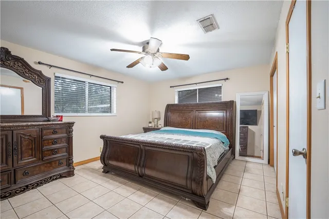 a bedroom with a bed and a ceiling fan