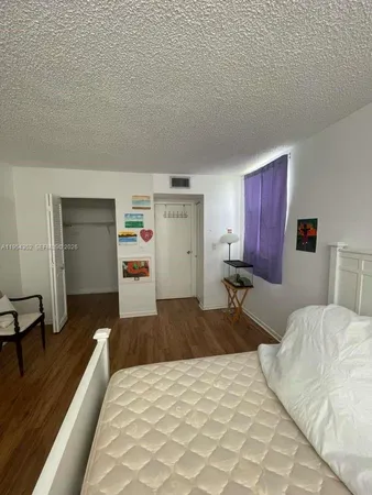 a bedroom with a bed and a large mirror on the dresser