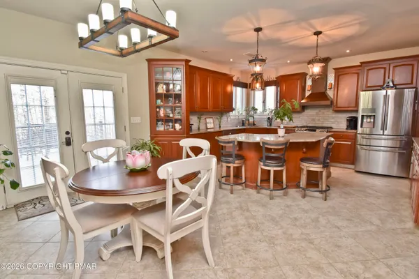 a kitchen with granite countertop kitchen island stainless steel appliances a sink stove and living room view